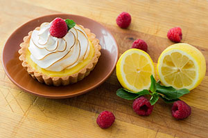 small lemon cake pie with raspberry on the top and around 