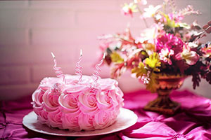 Pink Birthday Cake with rose shaped icing and curly candles.